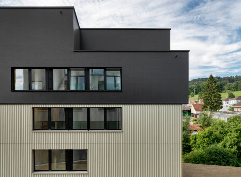 Trois immeubles d'habitation aux façades noires et vert olive Wohnpark Schäfliweg Bazenheid