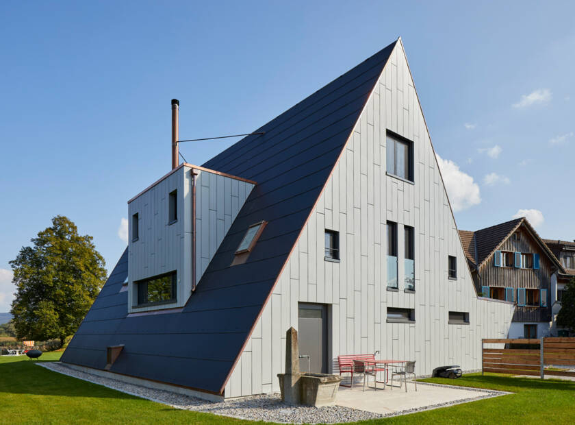 Maison grise avec toit en pente et solaire au sol Maison de la compagnie Loechligaischt à Eschenz